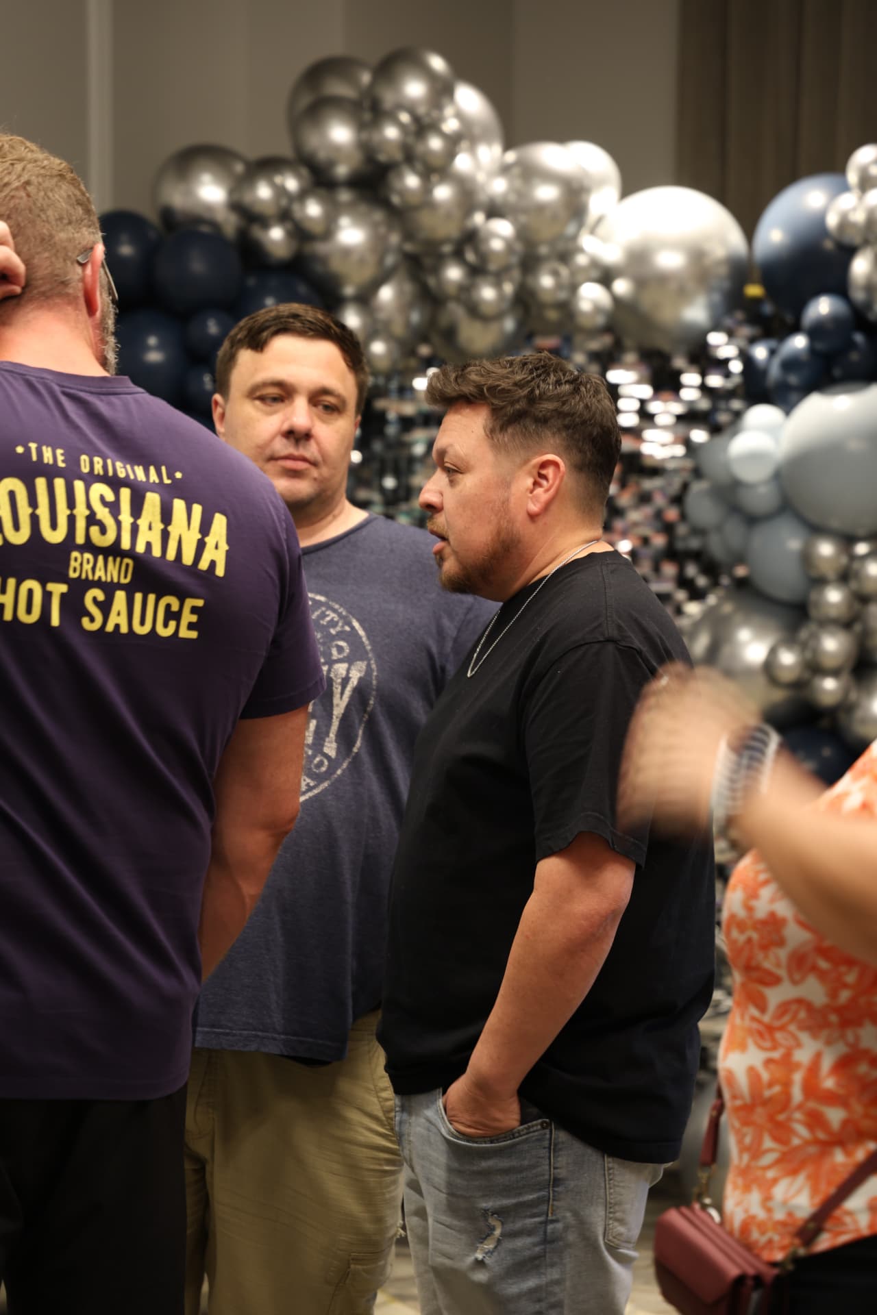Agents talking in front of a navy and silver balloon display