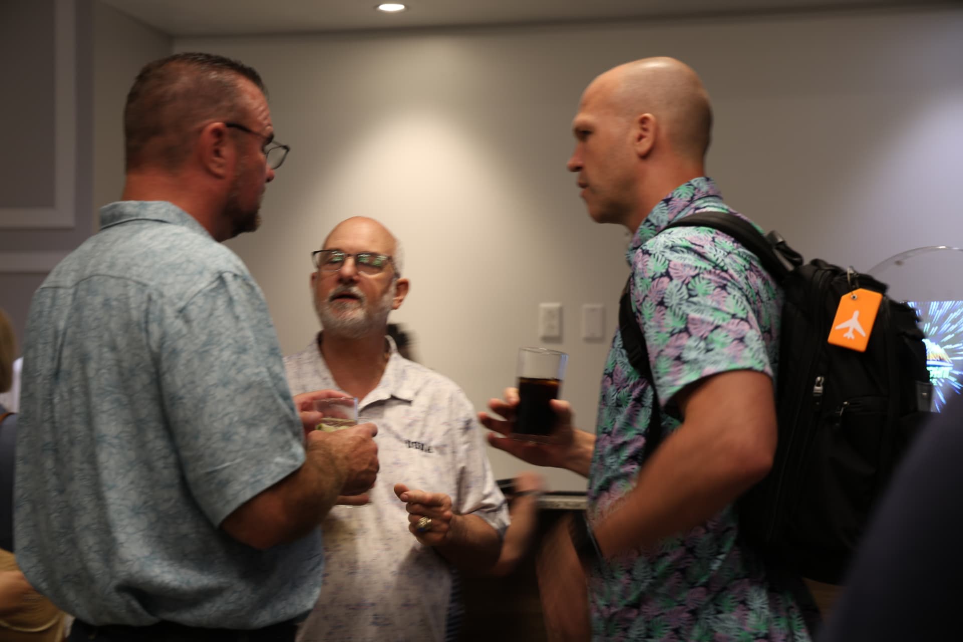 Three agents networking with drinks during a Topflight reception